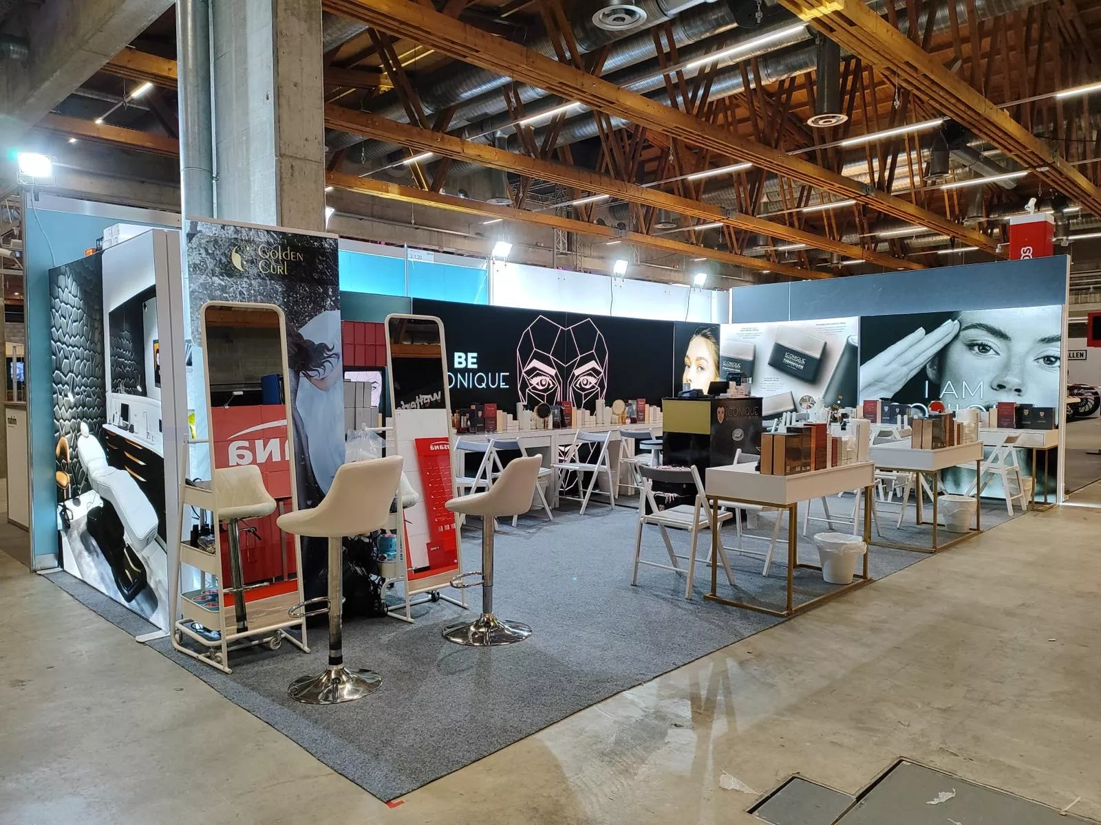 Iconique Skin Messestand mit goldenen Details, Spiegeln und Produktpräsentation