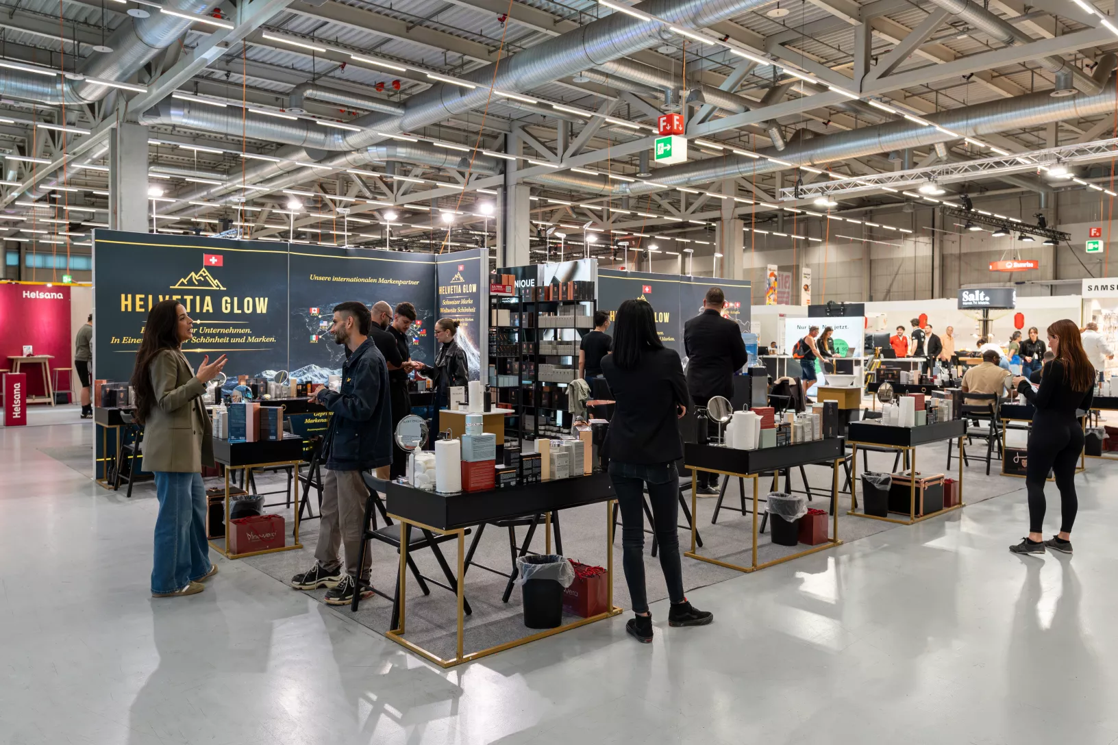 Helvetia Glow Messestand mit Besuchern und Produktdisplays