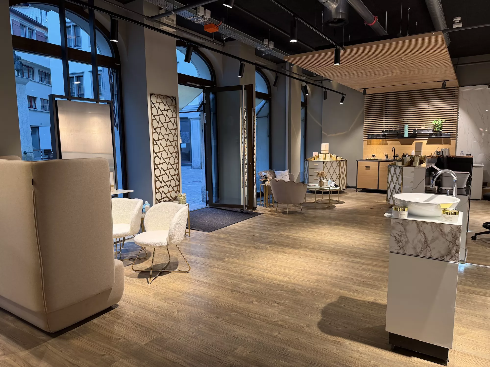 Helvetia Glow Boutique St. Gallen – Loungebereich mit Bogenfenstern und goldenen Akzenten